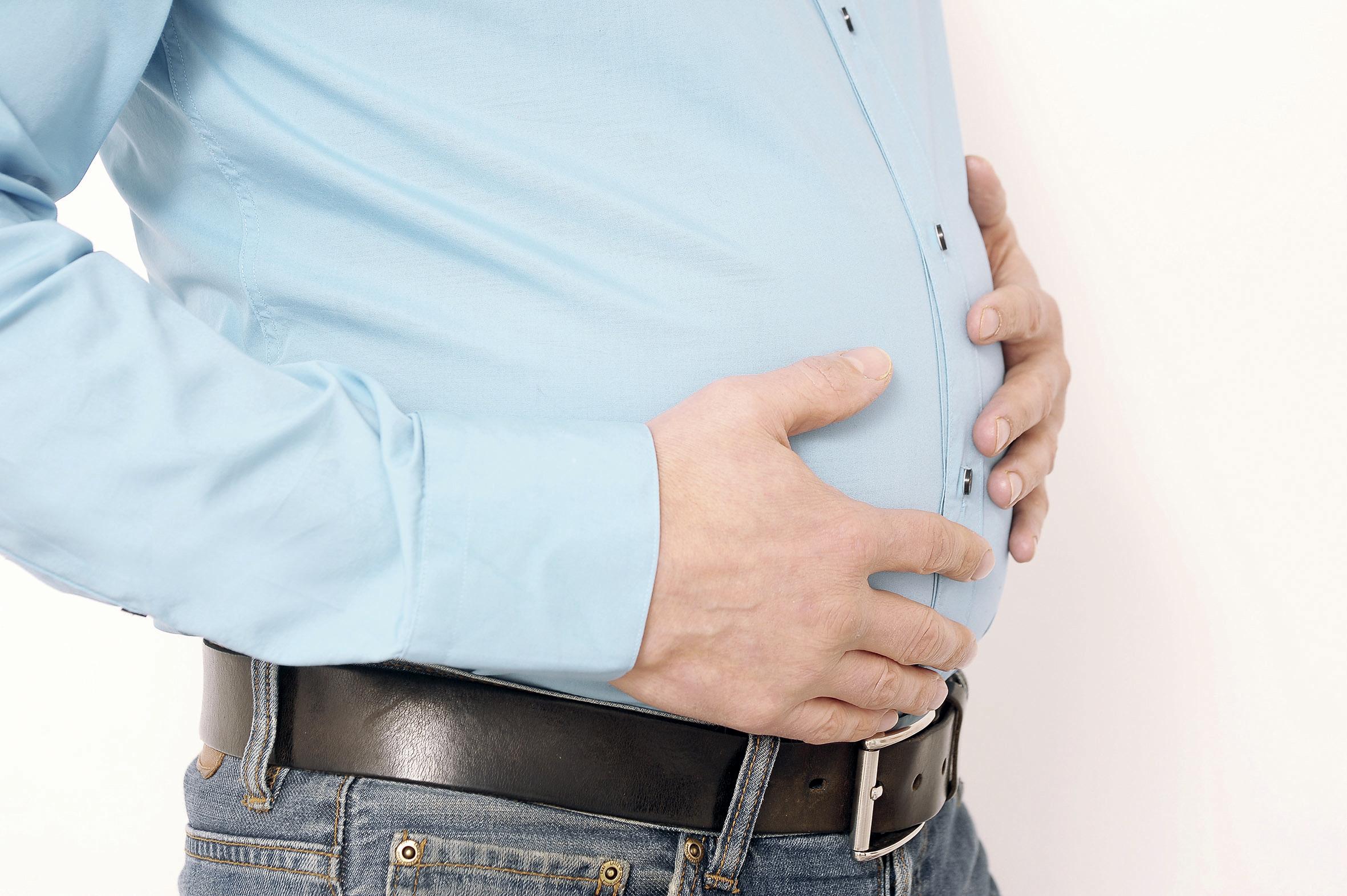 Mann hält sich seinen dicken Bauch